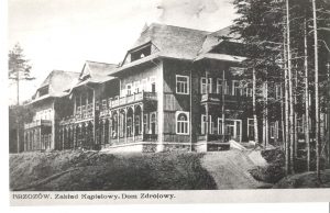 Czarno-białe zdjęcie budynku w stylu góralskim, ze spadzistym dachem